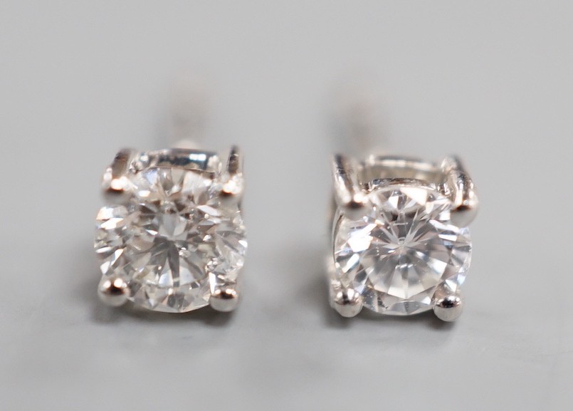 A modern pair of 9ct white gold and solitaire diamond set ear studs, gross 0.8 grams